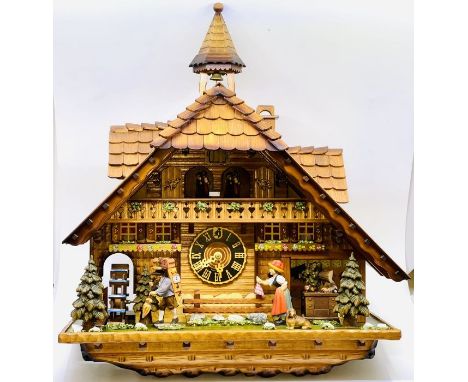 A German Black Forest carved cuckoo clock by Ingolf Haas, a chalet with dancing figures, Roman numeral dial and working figur