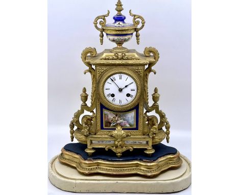 A late 19th Century French gilt spelter and porcelain mantle clock, porcelain urn finial, above a 3.5inch dial, roman numeral