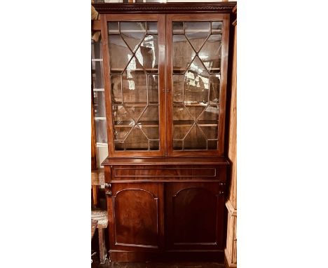 A George III and later mahogany bookcase, Chippendale revival, dental pediment above astragal glazed doors enclosing adjustab