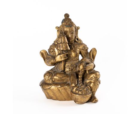 A SINO-TIBETAN GILT-BRONZE FIGURE OF KUBERACirca 18th century Seated on a raised mound holding a parasol and a mongoose vomit