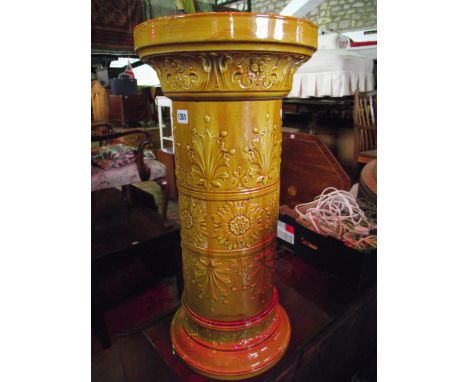 A late Victorian/Edwardian yellow glazed ceramic stick stand of cylindrical form with foliate detail