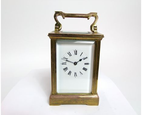 A brass carriage clock with reeded column supports and eight day time piece