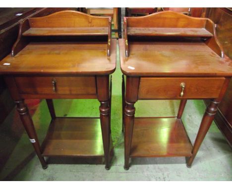 A pair of contemporary cherrywood bedside tables, each fitted with a frieze drawer raised on four turned tapered legs united 