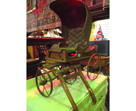 A small vintage toy pony trap with wire spoke iron wheels, sprung chassis and wooden frame, with central child's seat, with s
