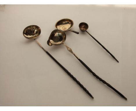 A miscellaneous collection of three Georgian silver toddy ladles, various makers and dates, each bowl inset with a coin, atta