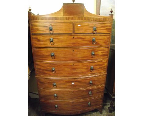 A Regency mahogany bow fronted chest on chest of six long and two short drawers, the shaped top with urn shaped finials with 