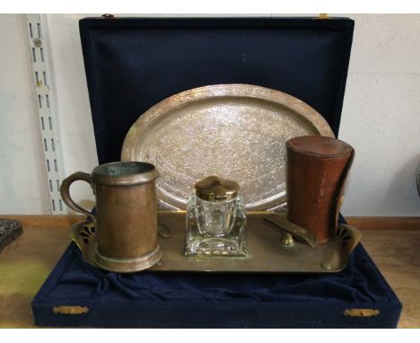 A cased Eastern white metal dish of oval form with embossed symmetrical detail, together with a brass desk standish, accommod