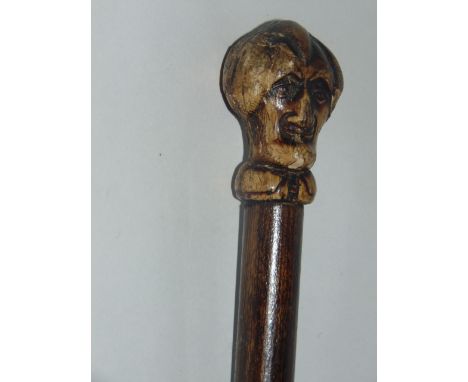 An antique sword/spike stick, encased in polished bamboo, the handle terminating in a worked horn finial in the form of Dr Sy