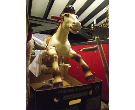 A vintage child's celluloid rocking horse with faux tan leather seat, suspended by four coiled springs and tubular steel red 