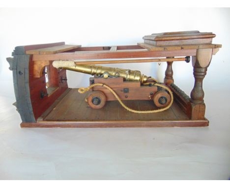A highly detailed timber model of a timber galleon cannon housing, the brass gun set upon a dual axled timber cart with detai