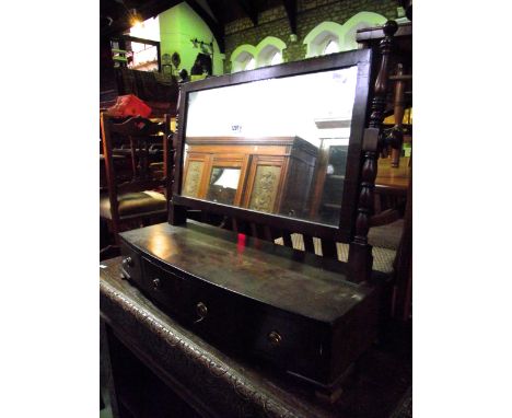 A 19th century mahogany toilet mirror of rectangular form with ringed turned columns raised on a box base with bow fronted ou