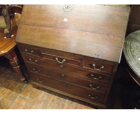 A Georgian country made oak bureau of three long and three short drawers, the fall flap enclosing the original stepped interi