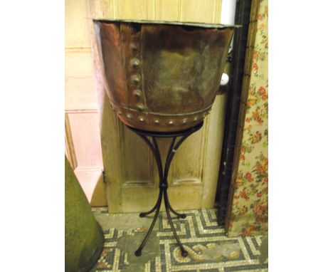 A vintage copper copper with riveted seams and pronounced lip, 50 cm in diameter approx, raised on a later contemporary stand