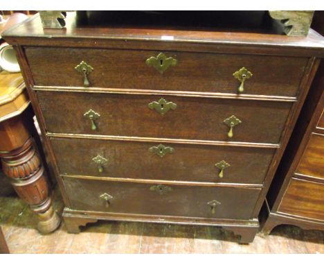 An Old English oak chest of four long graduated drawers with brass fittings on bracket supports, 94 cm wide approx