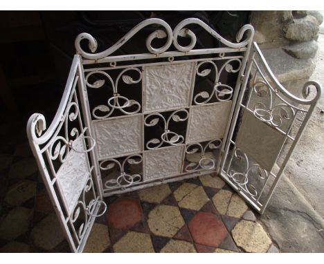 A contemporary three fold fire screen, the painted decorative cast metal frame with hinged circular rings with glass receptac