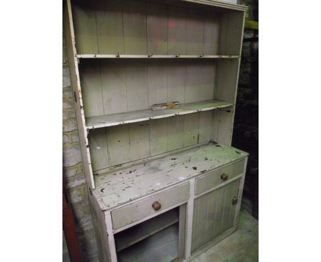 A vintage and rustic painted pine kitchen dresser, the base enclosed by a pair of sliding tongue and groove panelled doors be
