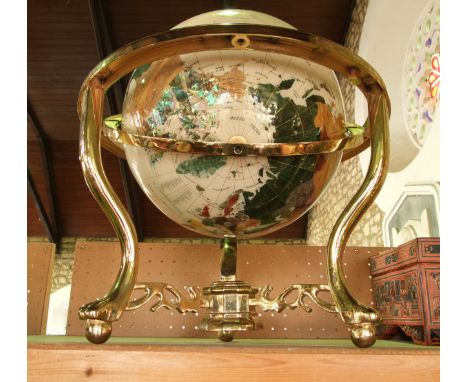 A decorative brightly coloured globe, composed from polished and cut semi-precious stones raised on a gilded axis and framewo