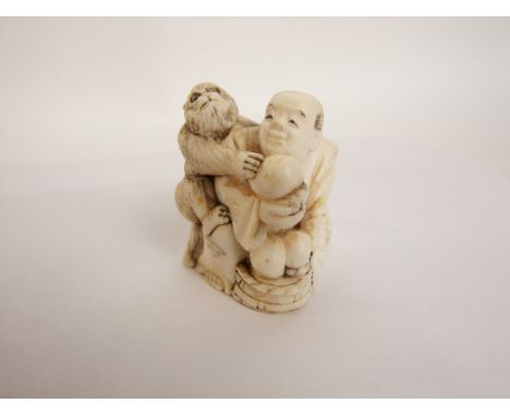 A late 19th/early 20th century Japanese ivory netsuke, seated man and playful monkey, 4 cm