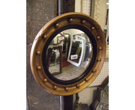 A Regency style convex wall mirror with reeded ebonised slip and ball surround, 43 cm diameter approx