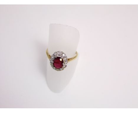 A ruby and diamond ring, centred with an oval mixed-cut untested ruby weighing approximately 0.96cts, within a surround of ro