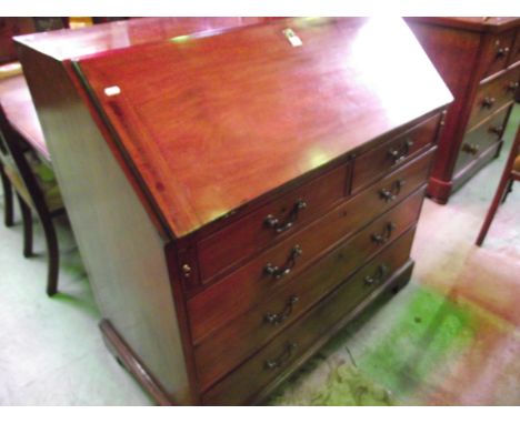A Georgian mahogany bureau, the fall flap enclosing a fitted interior of small drawers and pigeon holes flanking a central cu