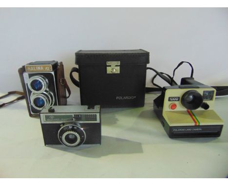 A cased polaroid land camera model 1000 together with a Halina AI 35mm lens camera, a AGFA ISOMAT-Rapid camera (3)