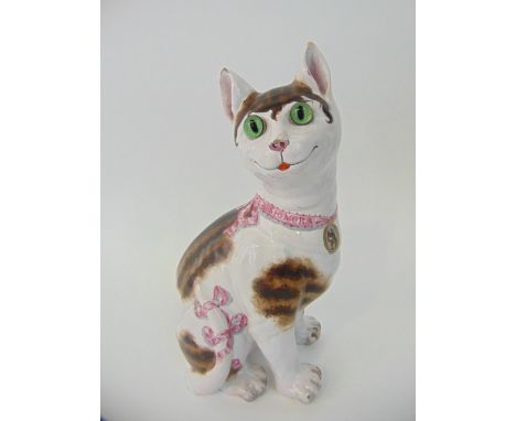 A 19th century Galle model of a seated cat, predominantly white with tabby patches and pink ribbons to her tail and matching 