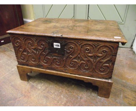 An 18th century oak bible box with rising lid, the front elevation with geometric carved detail set on later bracket supports