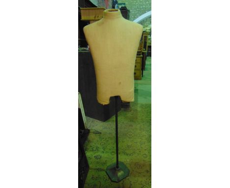 A vintage tailors mannequin (torso) raised on a central adjustable pole and swept platform base 