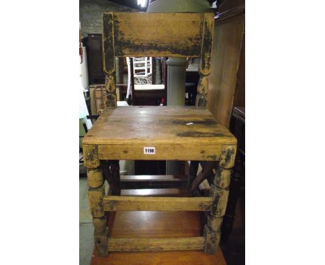 An antique pine chair with wide rail back over a solid seat raised on turned and block supports united by stretchers together