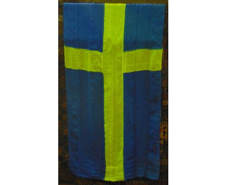 A large vintage Swedish flag suspended on a polish timber pole with brass pointed finial