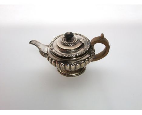 A William IV silver teapot, Charles Thomas Fox, London, 1831, the circular body with gadroon decoration, on a spreading foot,