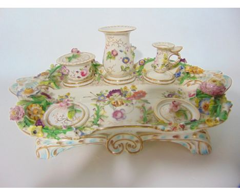 A mid 19th century Standish with well painted floral sprays and further floral encrusted decoration and fitted with two integ