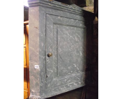 A vintage, probably 19th century, hanging corner cupboard enclosed by a fielded panelled door housing a painted interior with