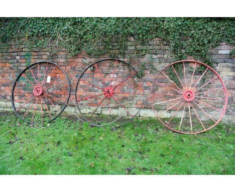 A pair of vintage implement wheels, with iron rims and spokes, 133cm in diameter approximately, together with one other (3)