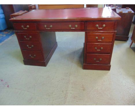 A vintage mahogany kneehole twin pedestal writing desk in the Georgian style with inset faux leather panelled top over the us