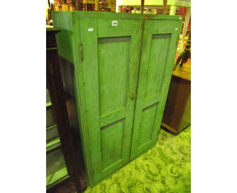 A vintage freestanding pained pine side cupboard enclosed by a pair of full length twin panelled doors, the interior shelved
