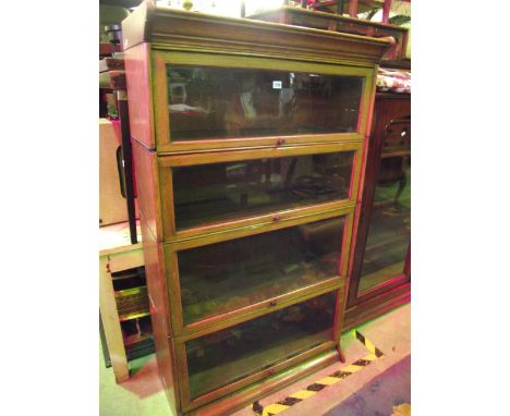 An Edwardian oak freestanding four sectional library bookcase in the Globe Wernicke style with moulded detail and up and over