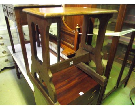 A vintage oak organ stool, the rectangular solid seat raised on open shaped supports united by a central rail/stretcher and r