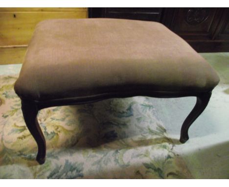 A stool, the upholstered seat with serpentine outline and carved foliate apron raised on shaped and moulded cabriole supports