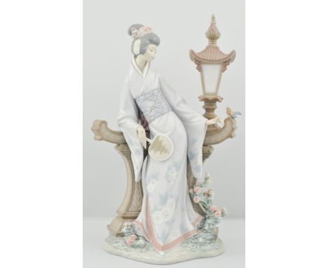 Lladro figure of a Japanese lady, dressed in kimono, standing along side a lamp with a bird, flowers and foliage, height 40cm