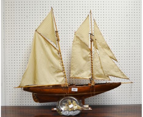 A model boat , Bluenose, on stand; a Ship in a bottle
