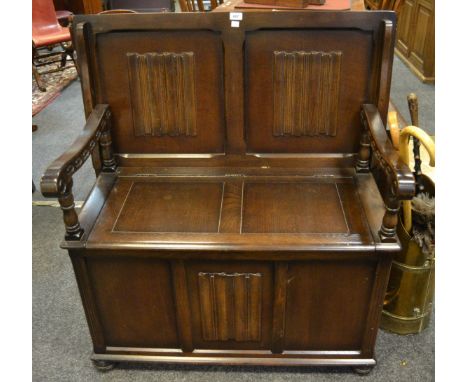 A late 20th century oak Monks bench, linen fold panels 