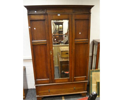 An early 20th Century oak wardrobe, ogee cornice, central mirrored door, one long drawer, bracket feet
