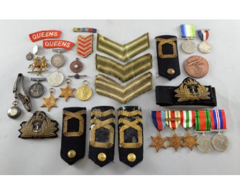 A collection of WWII service medals, military  badges, stripes and  epaulettes, and a Dutch bronze commemorative medallion