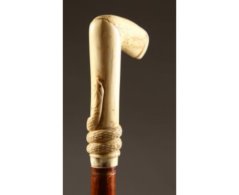 A BONE HANDLED WALKING STICK. carved with a snake. 39ins long.