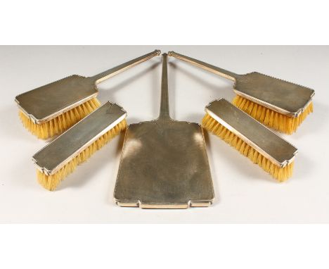 AN ENGINE TURNED FIVE PIECE DRESSING TABLE SET comprising hand mirror and four brushes. London 1939.