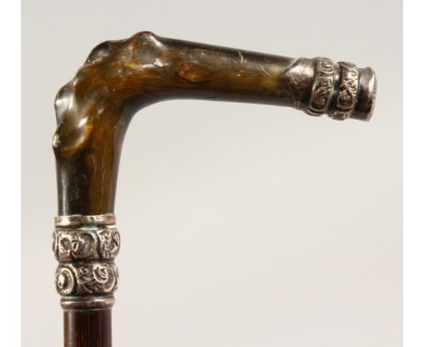 A 19TH CENTURY STICK, with carved horn handle and silver mounts. Birmingham 1867.  33ins long.