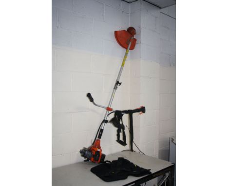 AN UNBRANDED PETROL STRIMMER with harness (engine pulls freely but hasn't been started)