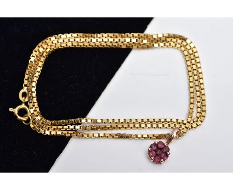 A YELLOW METAL RUBY PENDANT ON  A YELLOW METAL CHAIN, the pendant of circular form set with seven circular cut rubies fitted 